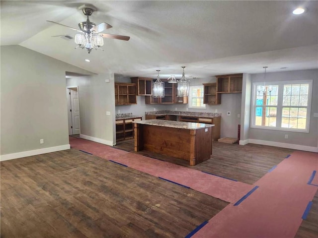 kitchen with dark wood-type flooring, lofted ceiling, a center island, and hanging light fixtures