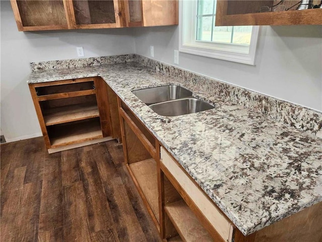 kitchen featuring sink, dark wood-type flooring, and light stone countertops