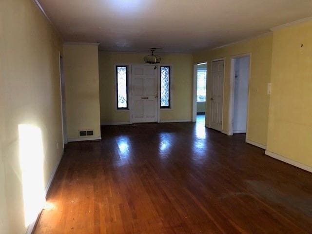 entrance foyer featuring visible vents, ornamental molding, baseboards, and wood finished floors