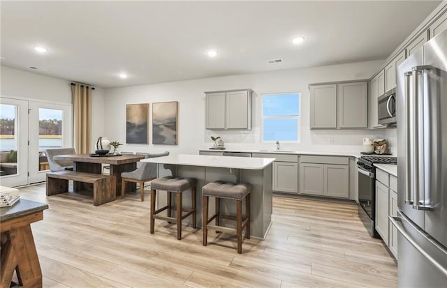 kitchen with a wealth of natural light, sink, gray cabinets, and stainless steel appliances