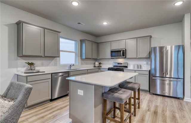 kitchen with light hardwood / wood-style floors, sink, stainless steel appliances, and decorative backsplash