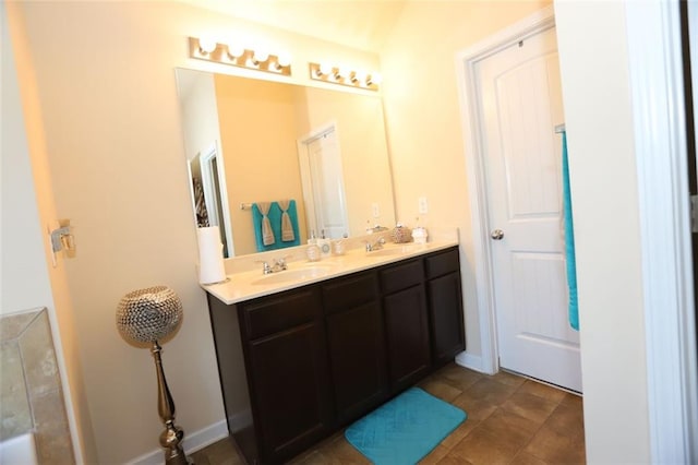full bath with tile patterned floors, double vanity, and a sink