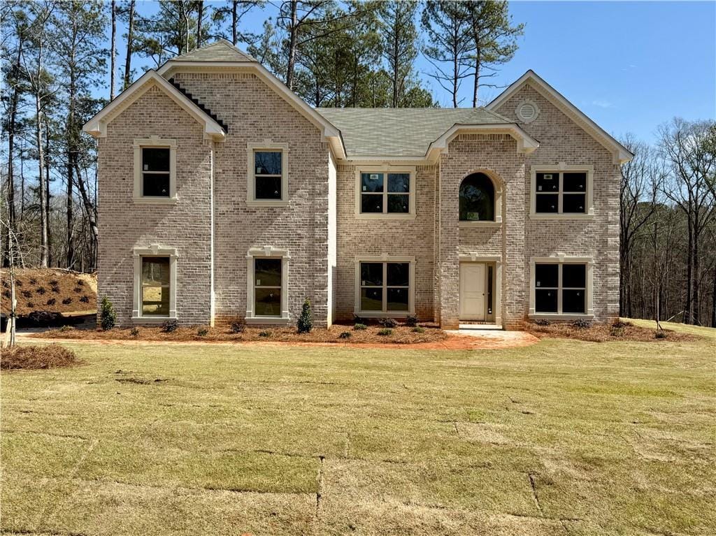 view of front of property featuring brick siding and a front lawn