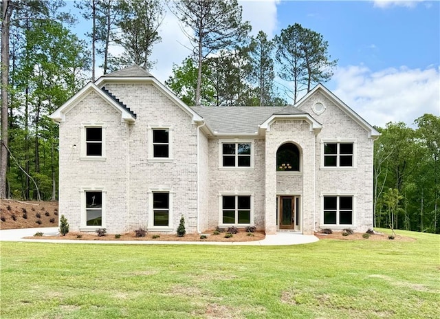 view of front of house featuring brick siding and a front yard