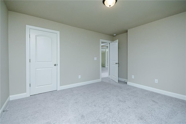 unfurnished bedroom with baseboards and carpet