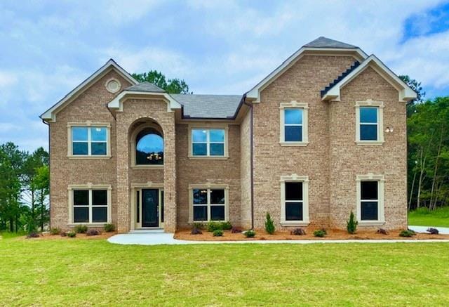 view of front of home featuring brick siding and a front lawn