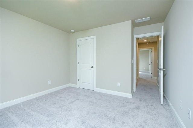 unfurnished bedroom with baseboards, visible vents, and light colored carpet