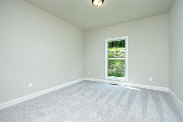 spare room featuring visible vents, carpet flooring, and baseboards