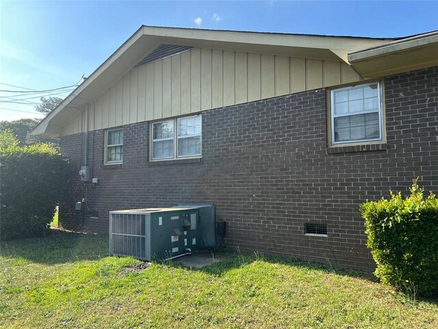 view of property exterior with a yard and central AC unit