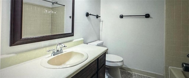 bathroom with toilet, vanity, and tile patterned flooring