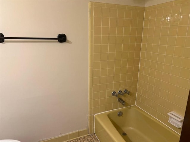 bathroom featuring tiled shower / bath combo and tile patterned flooring