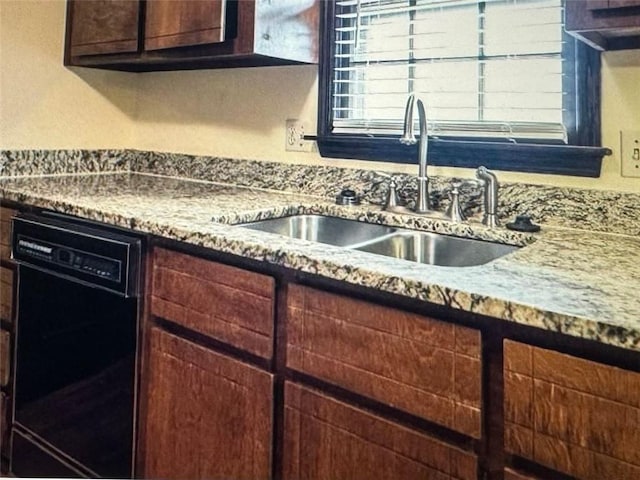 kitchen featuring dishwasher, dark brown cabinetry, sink, and light stone counters