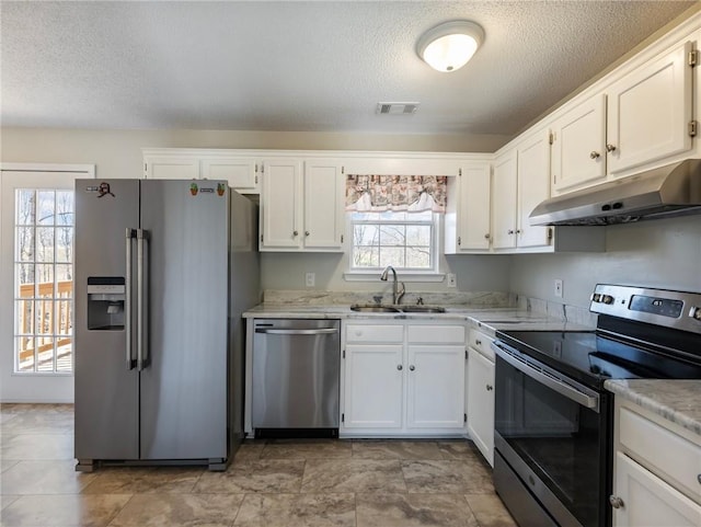 kitchen with visible vents, under cabinet range hood, light countertops, appliances with stainless steel finishes, and a sink