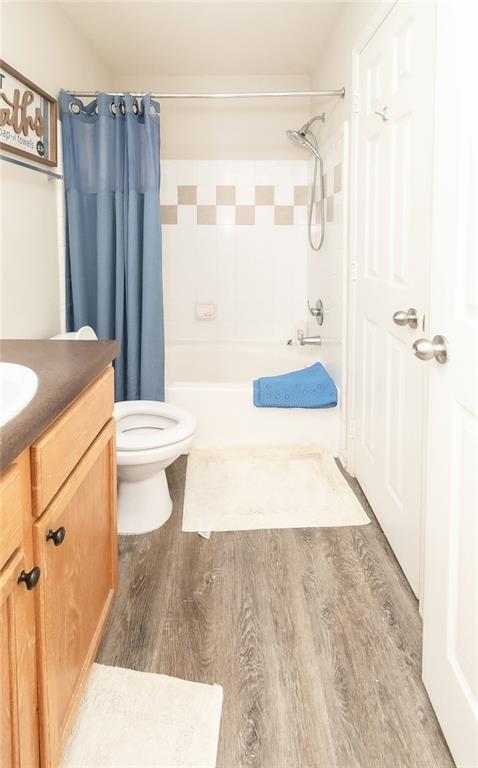 full bathroom with vanity, hardwood / wood-style floors, toilet, and shower / bath combo