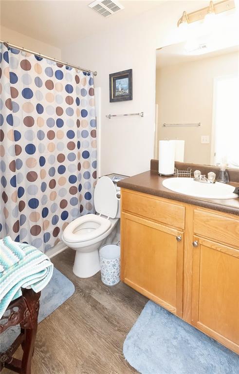 bathroom with vanity, toilet, a shower with shower curtain, and hardwood / wood-style flooring