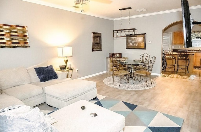 living room featuring crown molding, hardwood / wood-style floors, and ceiling fan