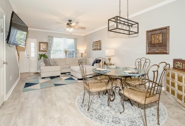 dining space featuring crown molding, light hardwood / wood-style floors, and ceiling fan