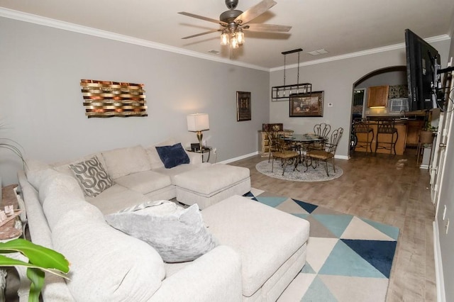 living room featuring ceiling fan, hardwood / wood-style floors, and crown molding