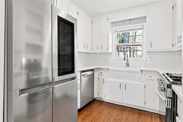 2199 Summertown Dr, Norcross, GA 30071 - kitchen with stainless steel appliances, white cabinets, light countertops, dark wood finished floors, and decorative backsplash