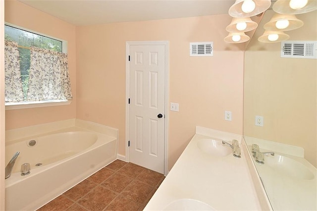 bathroom featuring a tub to relax in, tile patterned floors, vanity, and plenty of natural light