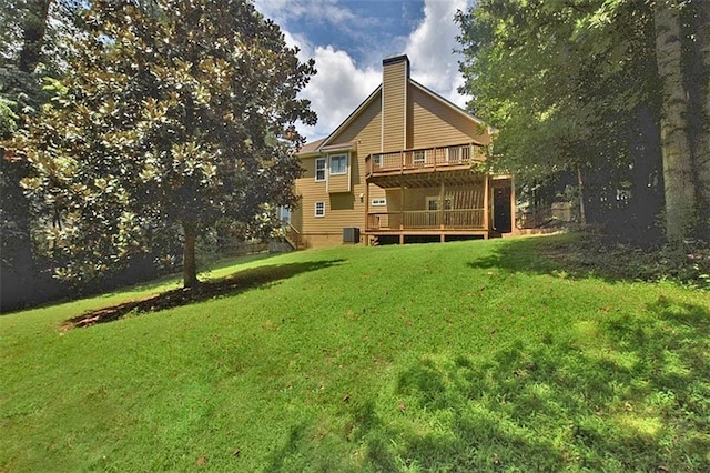 rear view of property featuring central AC, a deck, and a lawn