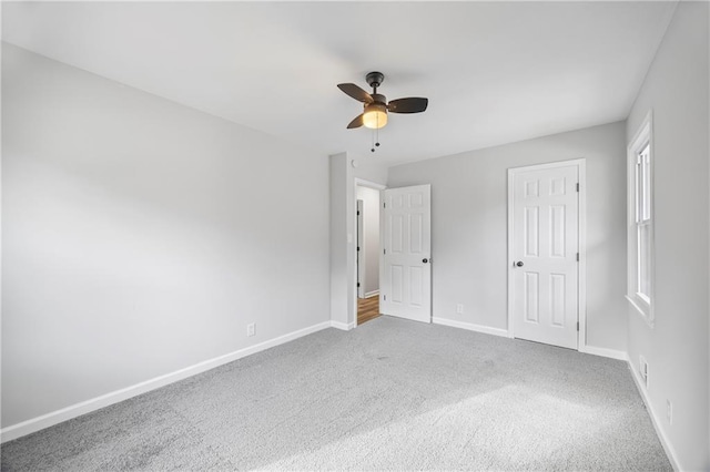 unfurnished bedroom featuring multiple windows, ceiling fan, a closet, and carpet floors