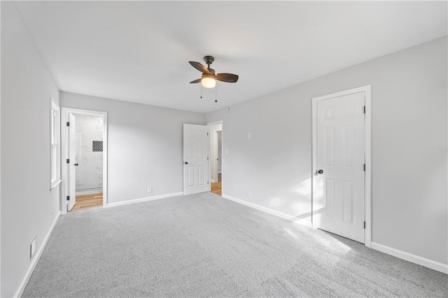 unfurnished bedroom featuring light carpet, ensuite bath, and ceiling fan