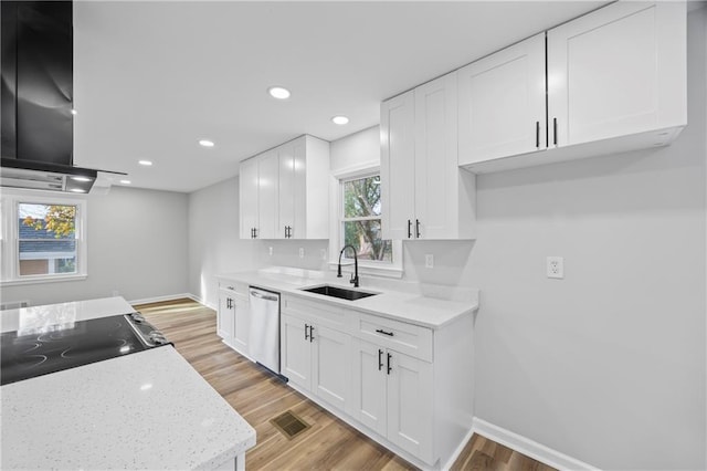 kitchen featuring exhaust hood, sink, stainless steel dishwasher, light hardwood / wood-style floors, and white cabinetry