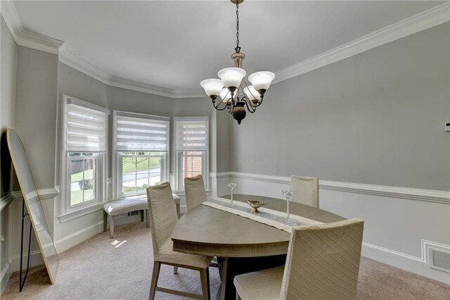 carpeted dining area featuring ornamental molding and an inviting chandelier