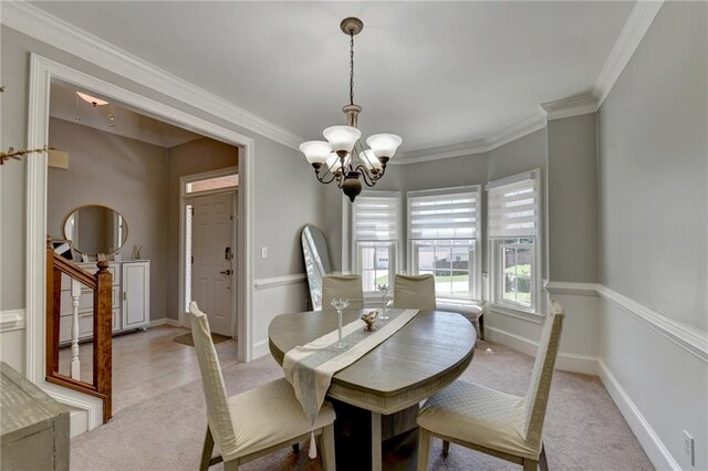 carpeted dining area with ornamental molding and an inviting chandelier