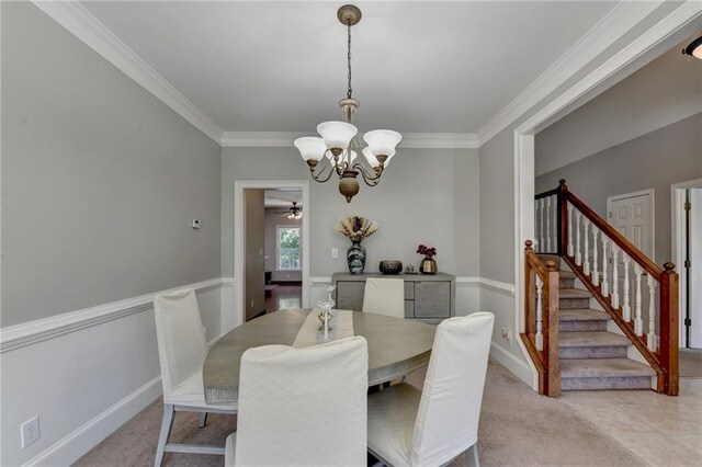 carpeted dining room with ceiling fan with notable chandelier and ornamental molding