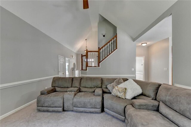 living room with high vaulted ceiling and carpet flooring