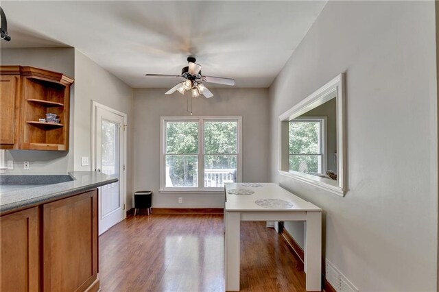 unfurnished dining area featuring ceiling fan and dark hardwood / wood-style flooring