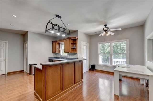 kitchen featuring decorative light fixtures, ceiling fan, and light hardwood / wood-style floors