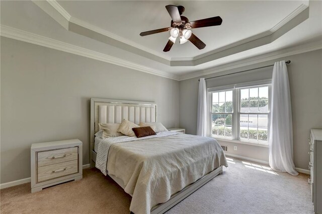 carpeted bedroom with ornamental molding, a raised ceiling, and ceiling fan