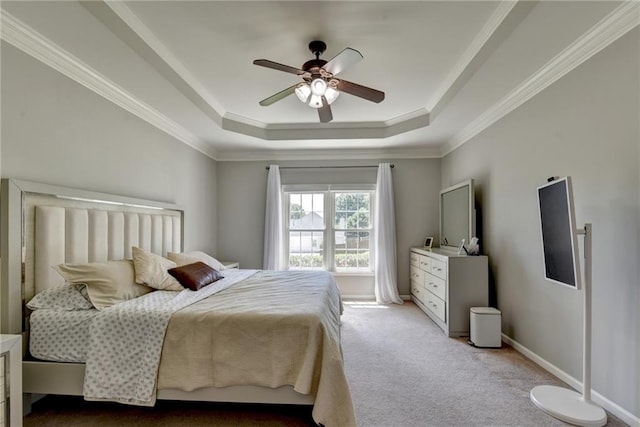 carpeted bedroom featuring a tray ceiling, ceiling fan, and ornamental molding