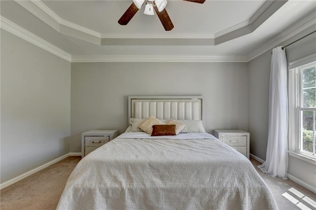 carpeted bedroom featuring ornamental molding, multiple windows, a raised ceiling, and ceiling fan