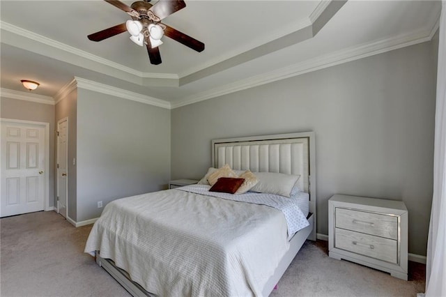 carpeted bedroom featuring crown molding, a tray ceiling, and ceiling fan