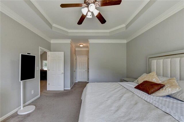 carpeted bedroom with a raised ceiling, ceiling fan, and ornamental molding