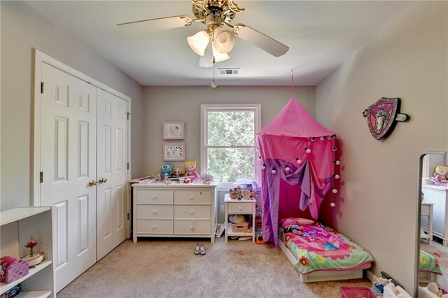 carpeted bedroom featuring ceiling fan and a closet