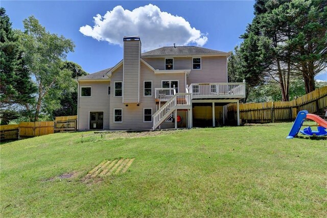 rear view of house with a yard and a deck