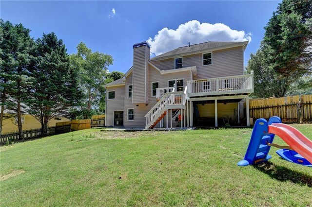 rear view of property with a yard and a wooden deck