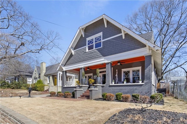 craftsman inspired home with a porch, ceiling fan, and fence