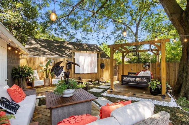 view of patio / terrace with a deck, an outdoor living space, a fenced backyard, and an outdoor structure