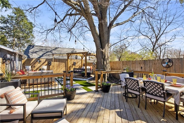 wooden terrace with outdoor dining area, an outdoor hangout area, and a fenced backyard