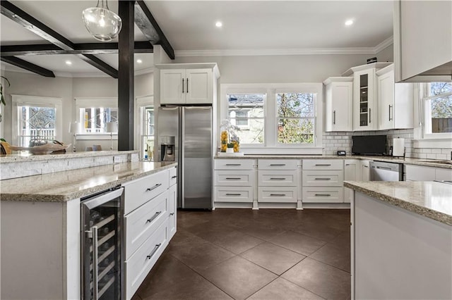 kitchen featuring light stone countertops, beverage cooler, appliances with stainless steel finishes, white cabinetry, and backsplash