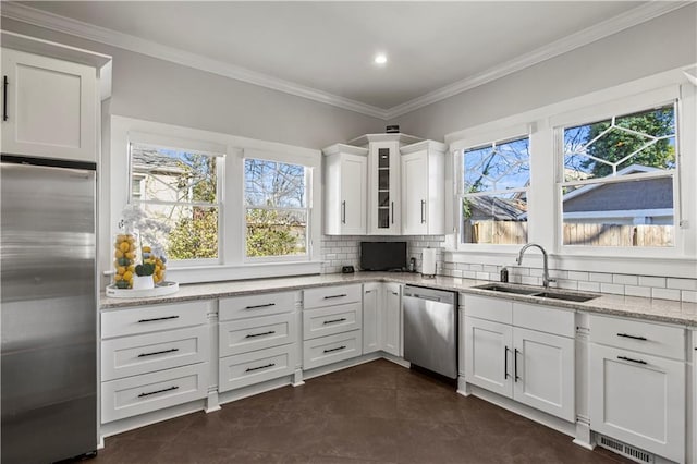 kitchen featuring a sink, stainless steel appliances, white cabinets, crown molding, and decorative backsplash