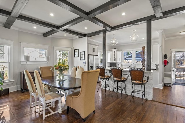 dining space with beam ceiling, coffered ceiling, a healthy amount of sunlight, and dark wood finished floors