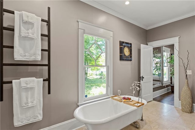 full bathroom with baseboards, a soaking tub, and ornamental molding