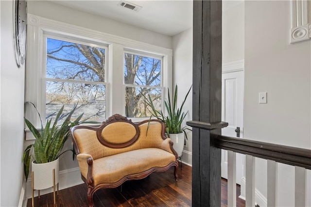 sitting room featuring visible vents, baseboards, and wood finished floors